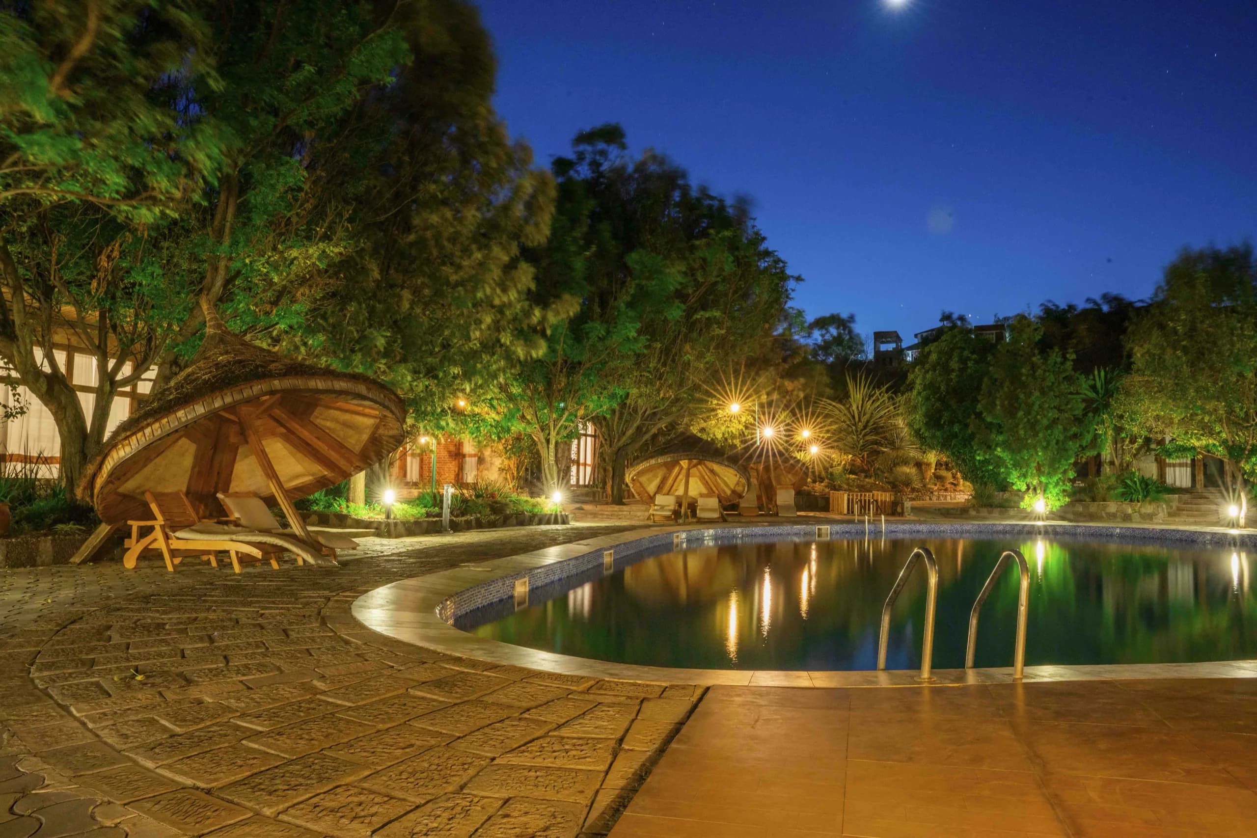 A pool and gardens lit at dusk