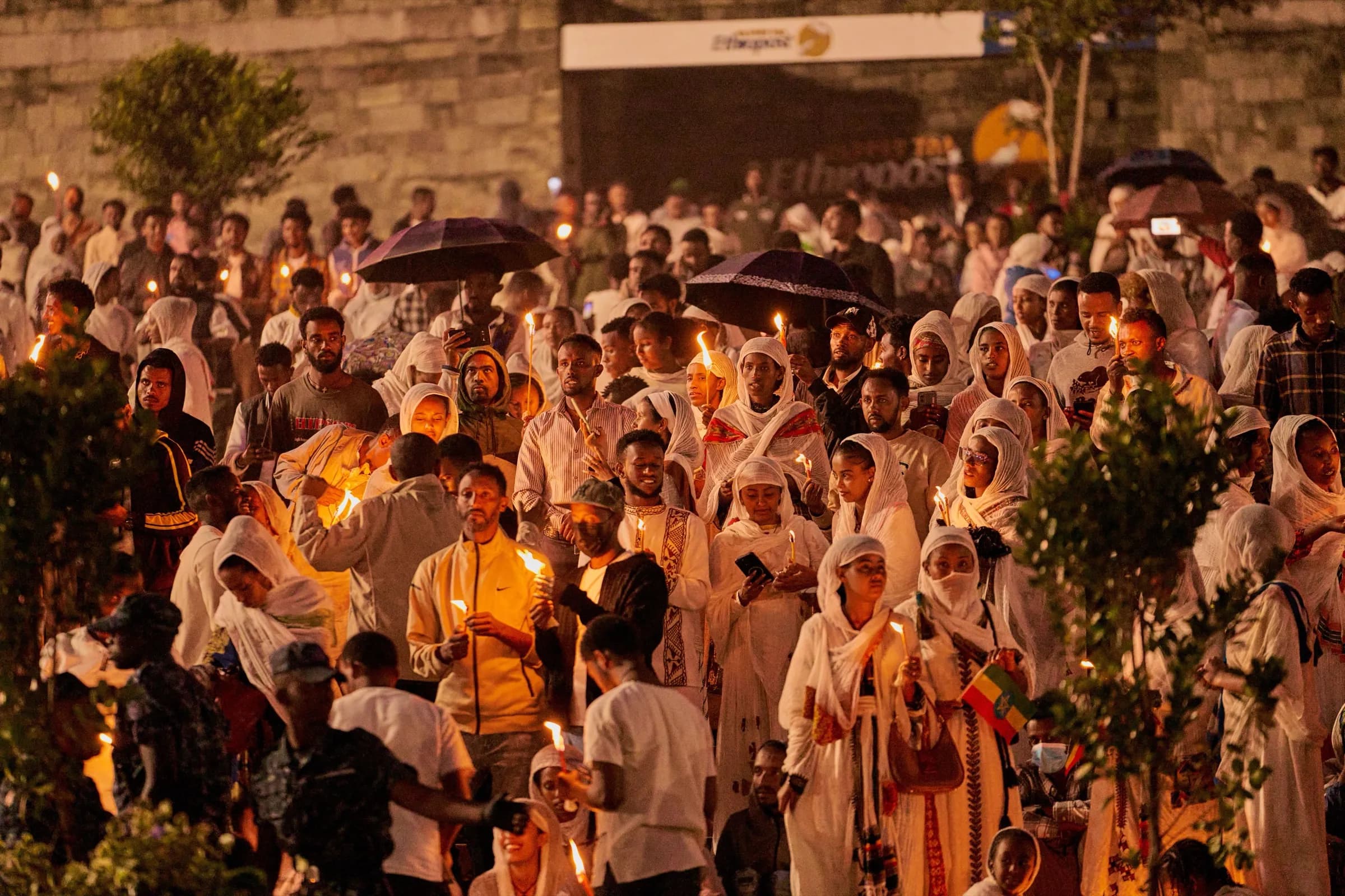 Candlelit crowd gathered in white at night